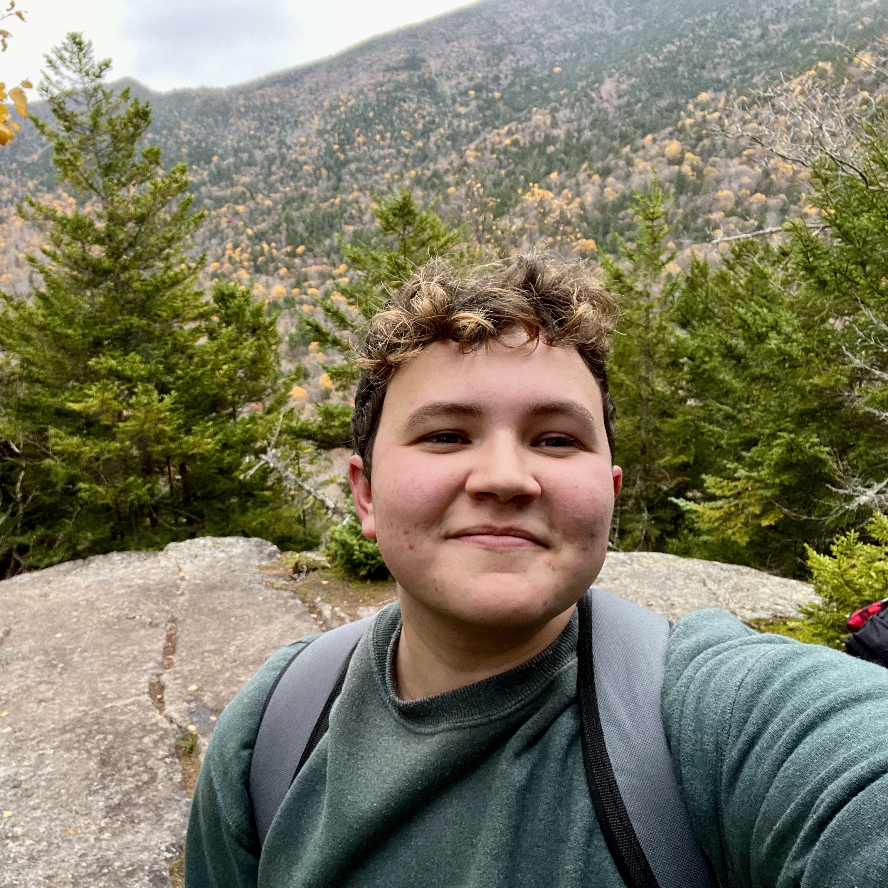 A selfie of Charlie in the mountains with fall foliage